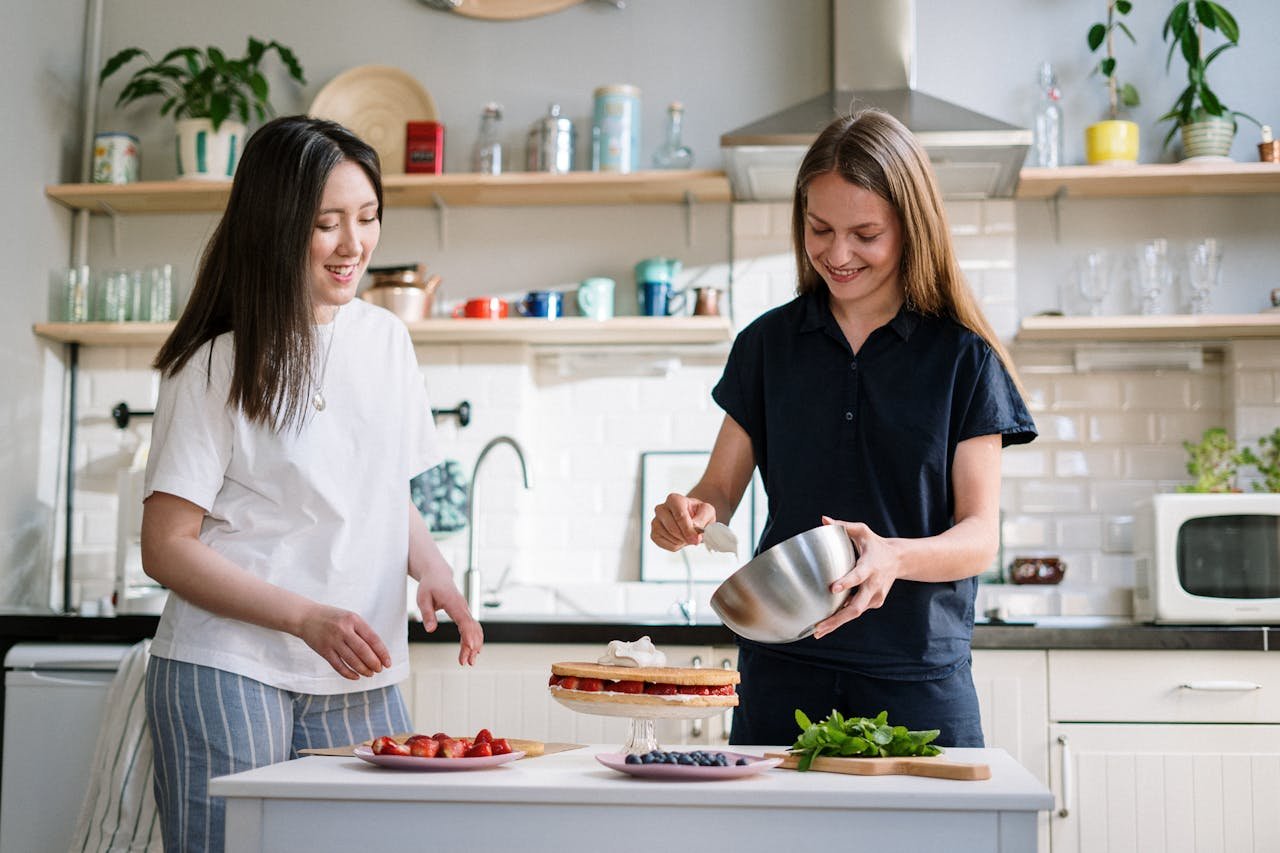 Two women enjoy baking a delicious cake together in a bright and cozy home kitchen.
